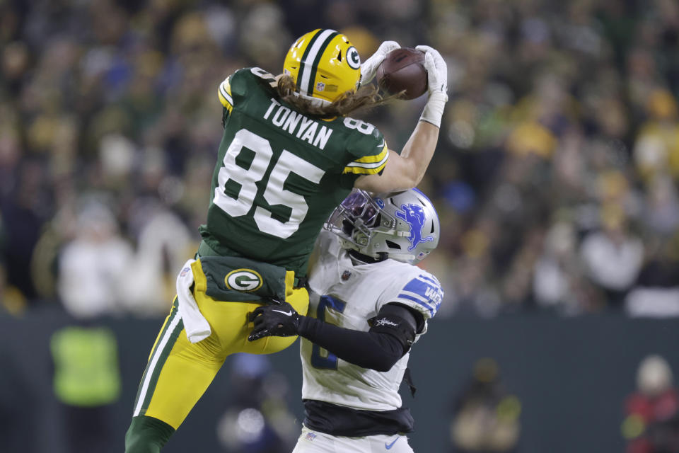 Green Bay Packers tight end Robert Tonyan (85) catches a pass as Detroit Lions safety DeShon Elliott defends during the first half of an NFL football game Sunday, Jan. 8, 2023, in Green Bay, Wis. (AP Photo/Matt Ludtke)