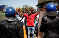 <p>A supporter of the Movement for Democratic Change (MDC) opposition party of Nelson Chamisa gestures to the riot police as they march on the streets of Harare, Zimbabwe, August 1, 2018. (Photo: Siphiwe Sibeko/Reuters) </p>