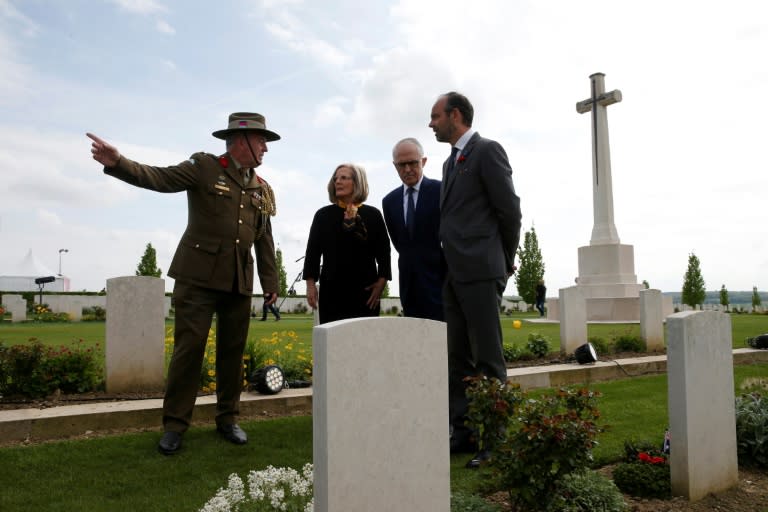 Australian Colonel Scott Clingan escorts French Prime Minister Edouard Philippe (right) and Australian Prime Minister Malcolm Turnbull (second right) and his wife Lucy through the military cemetery in Villers-Bretonneux