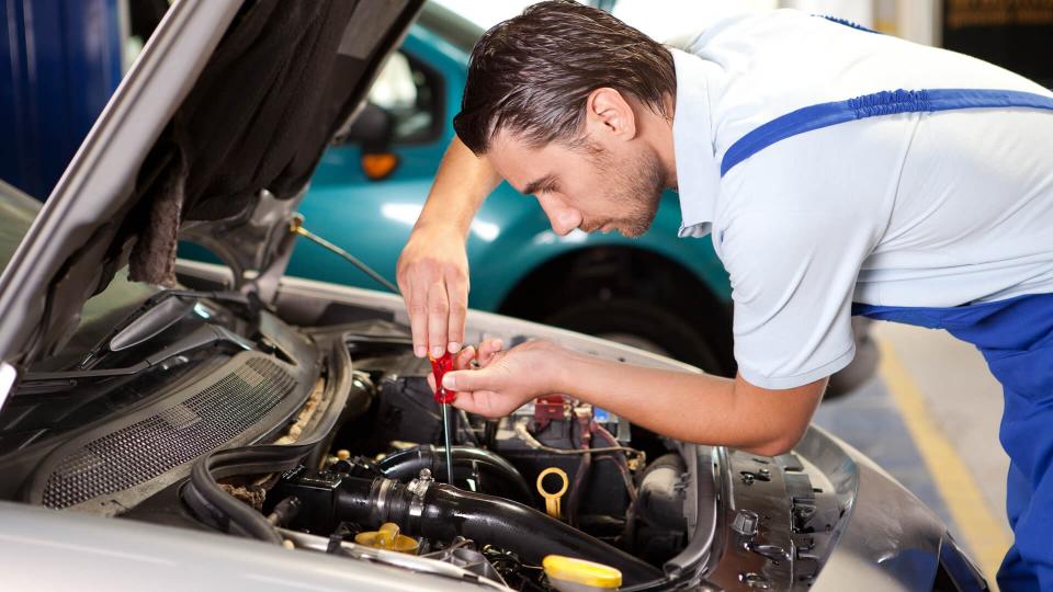 Repairman is working in repair shop.