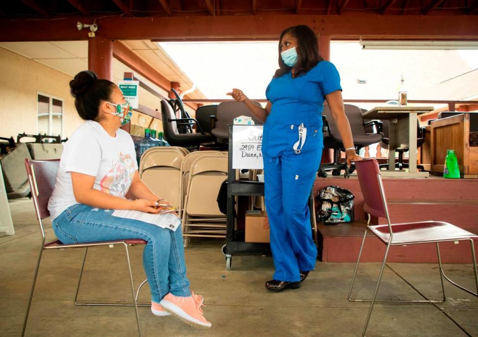 Farmworker Andrea Ortiz, left, talks with Teresa Hurtt after receiving her COVID-19 vaccine at the Episcopal Farmworker Ministry, on Saturday, Apr. 10, 2021, in Dunn, N.C.