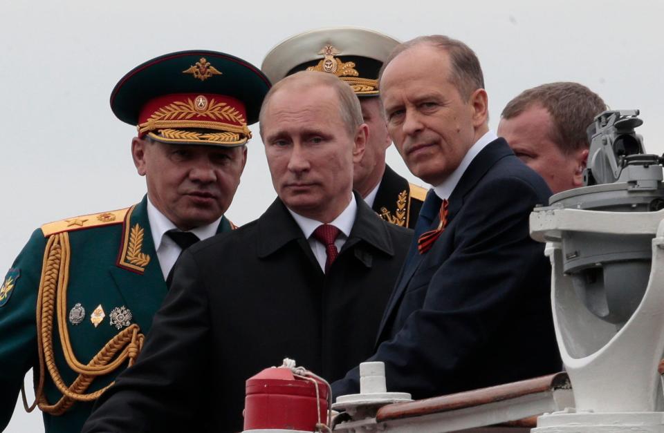 Russian President Vladimir Putin, flanked by Defense Minister Sergei Shoigu, left, and Federal Security Service Chief Alexander Bortnikov, right, arrives on a boat after inspecting battleships during a navy parade marking the Victory Day in Sevastopol, Crimea, Friday, May 9, 2014. Putin extolled the return of Crimea to Russia before tens of thousands during his first trip to the Black Sea peninsula since its annexation. The triumphant visit was quickly condemned by Ukraine and NATO.