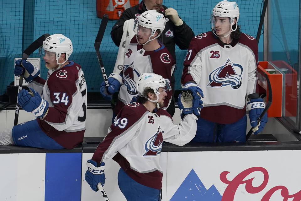 Colorado Avalanche defenseman Samuel Girard, bottom, is congratulated by teammates after scoring against the San Jose Sharks during the third period of an NHL hockey game in San Jose, Calif., Wednesday, March 3, 2021. (AP Photo/Jeff Chiu)