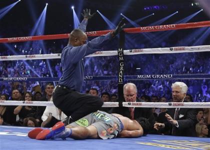 Referee Kenny Bayless calls the fight as he kneels over Manny Pacquiao. (AP)