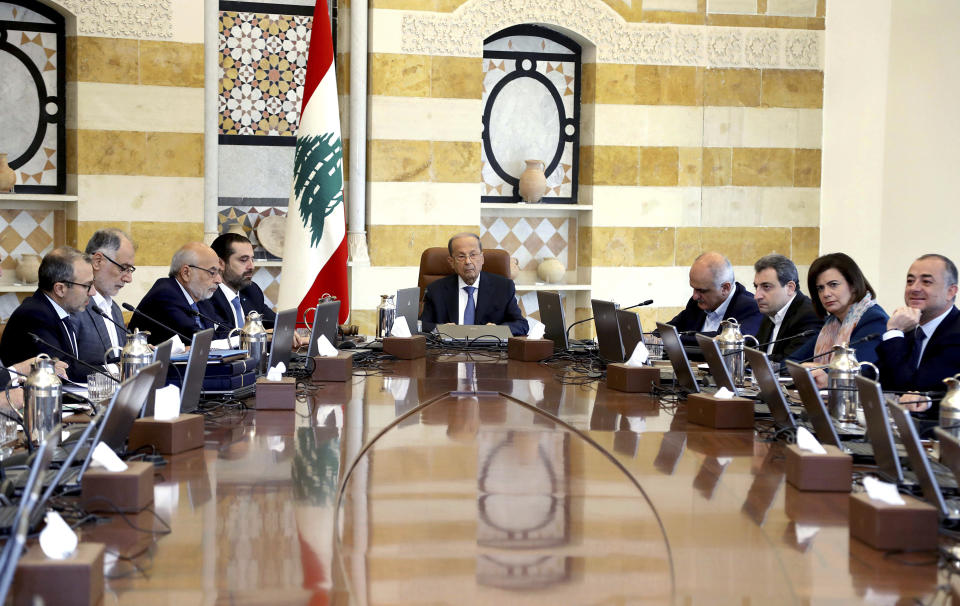 In this photo released by Lebanon's official government photographer Dalati Nohra, Lebanese President Michel Aoun, center, heads the cabinet meeting, at the presidential palace, in Baabda, east of Beirut, Lebanon, Monday, Oct. 21, 2019. Protesters closed major roads around Lebanon ahead of an emergency cabinet meeting on Monday, as politicians scrambled to put together a rescue plan for the country's crumbling economy and stem five days of mass anti-government protests. (Dalati Nohra via AP)