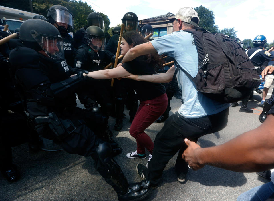 <p>Police dressed in riot gear tussle with counter-protesters.</p>