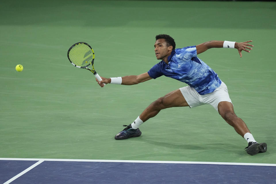 Felix Auger-Aliassime, of Canada, returns a shot to Carlos Alcaraz, of Spain, at the BNP Paribas Open tennis tournament Thursday, March 16, 2023, in Indian Wells, Calif. (AP Photo/Mark J. Terrill)