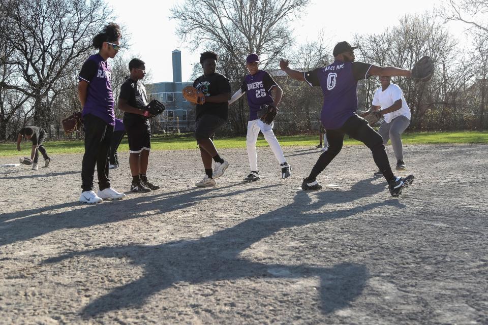 Vincent McMullen, known as Coach Mac, demonstrates pitching to players of the Motor City Ravens youth baseball team during practice at Calcara Park in Detroit on Wednesday, April 13, 2023.