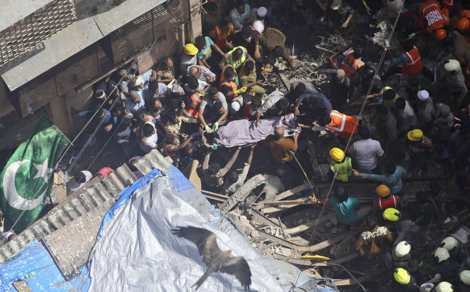 Rescuers carry the body of a victim at the site of a building that collapsed in Mumbai, India, Tuesday, July 16, 2019. A four-story residential building collapsed Tuesday in a crowded neighborhood in Mumbai, India's financial and entertainment capital, and several people were feared trapped in the rubble, an official said. (AP Photo/Rajanish Kakade)