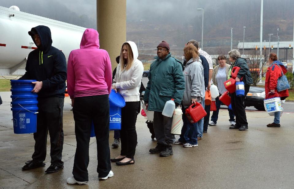 People wait in line for water from a 7500 gallon tanker truck brought in from Washington, Pa., on Friday, Jan. 10, 2014, at Riverside High School near Charleston, W.Va. A chemical spill left the water for 300,000 people in and around West Virginia's capital city stained blue-green and smelling like licorice, with officials saying Friday it was unclear when it might be safe again for even mundane activities like showers and laundry. (AP Photo/The Daily Mail, Craig Cunningham)