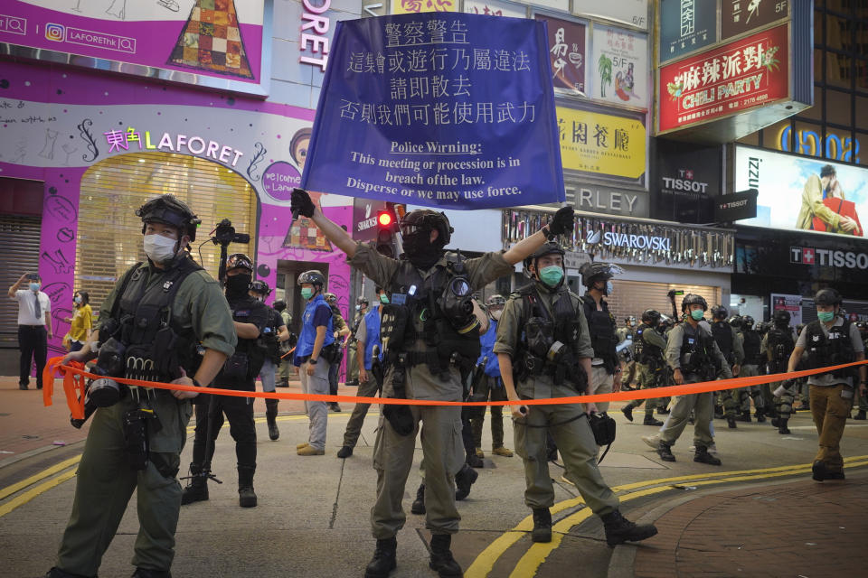 Riot police display warning banner during a protest in Causeway Bay, Hong Kong, Friday, June 12, 2020. Protesters in Hong Kong got its government to withdraw extradition legislation last year, but now they're getting a more dreaded national security law, and the message from Beijing is that protest is futile. (AP Photo/Vincent Yu)