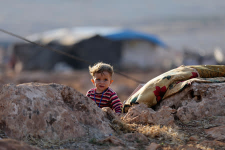 A newly displaced Syrian child walks near a refugee camp in Atimah village, Idlib province, Syria September 11, 2018. REUTERS/Khalil Ashawi