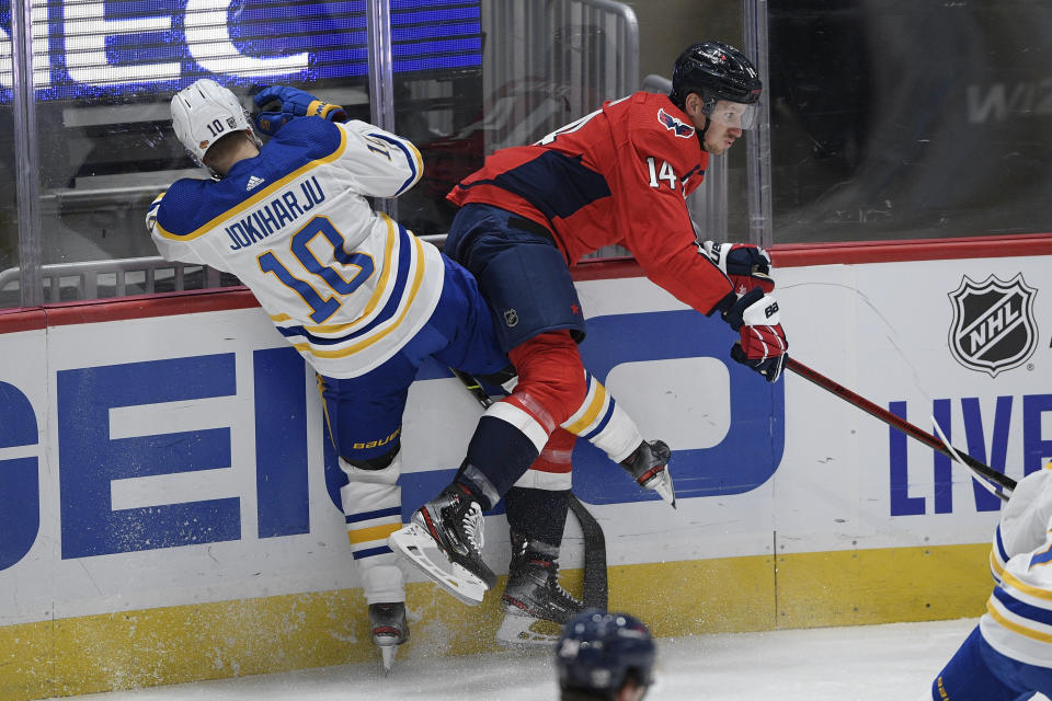 Buffalo Sabres defenseman Henri Jokiharju (10) and Washington Capitals right wing Richard Panik (14) collide during the first period of an NHL hockey game, Sunday, Jan. 24, 2021, in Washington. (AP Photo/Nick Wass)