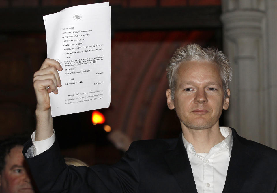 Julian Assange holding a document. Source: Reuters