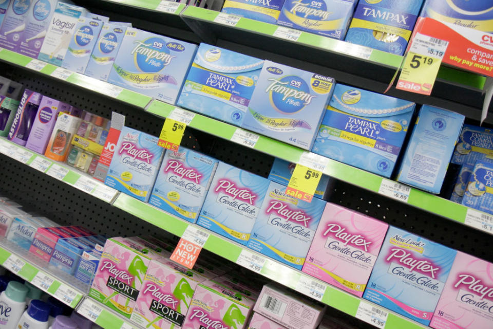 Shelf in a store stocked with various brands and types of feminine hygiene products