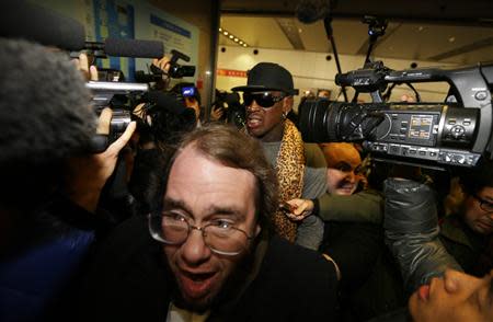 Former NBA basketball player Dennis Rodman is surrounded by the media as he returns from his trip to North Korea at Beijing airport, December 23, 2013. REUTERS/Jason Lee