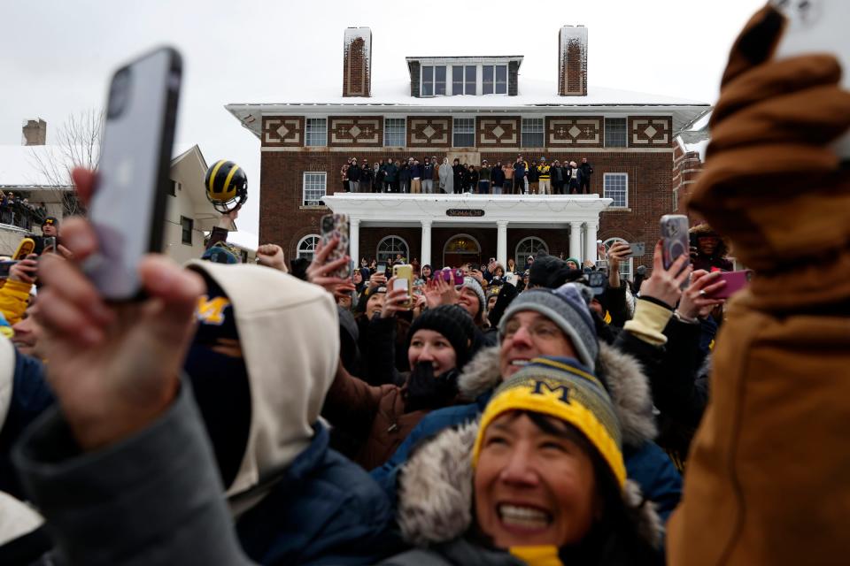 Michigan fans and members of the Sigma Chi fraternity yell and cheer as the Michigan football team and newly crowned National Champions come down South State Street in pickup trucks and old fire trucks during a parade on campus in Ann Arbor on Saturday, January 13, 2024.