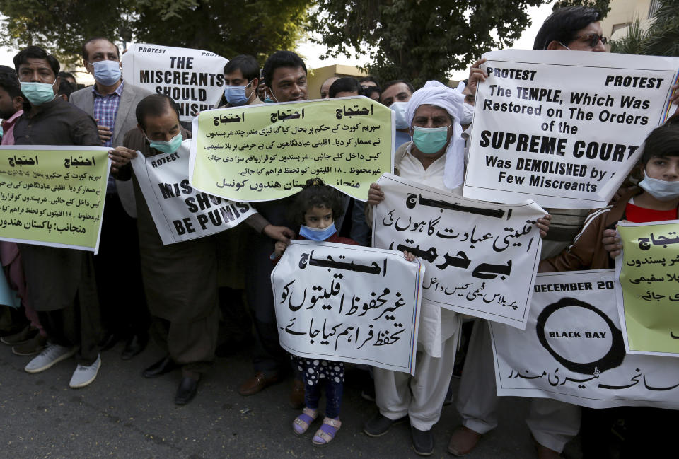 Members of Pakistan Hindu Council hold a protest against the attack on a Hindu temple in the northwestern town of Karak, in Karachi, Pakistan, Thursday, Dec. 31, 2020. Pakistani police arrested 14 people in overnight raids after a Hindu temple was set on fire and demolished by a mob led by supporters of a radical Islamist party, officials said. The temple's destruction Wednesday in the northwestern town of Karak drew condemnation from human rights activists and the minority Hindu community. (AP Photo/Fareed Khan)