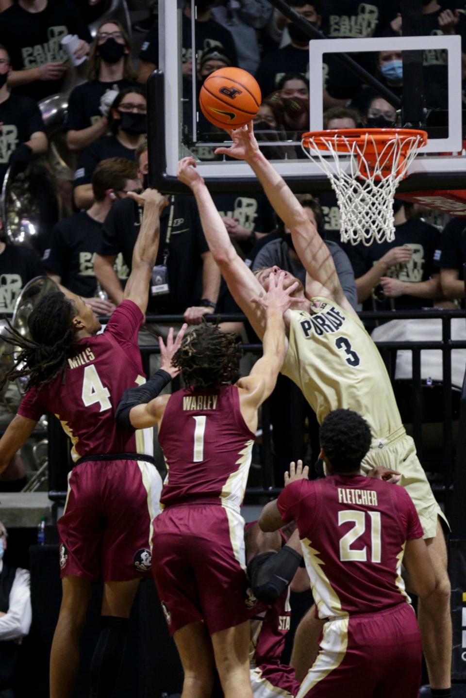 Purdue forward Caleb Furst (3) goes up to tip the rebound into the basket against Florida State guard Caleb Mills (4) and Florida State guard Jalen Warley (1) during the first half of an NCAA men's basketball game, Tuesday, Nov. 30, 2021 at Mackey Arena in West Lafayette.