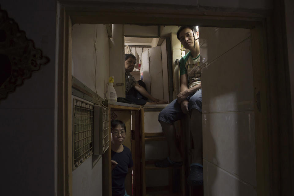 <p>Li Suet-wen and her son, 6, and daughter, 8, live in a 120-square-foot room crammed with a bunk bed, small couch, refrigerator, washing machine and small table, in an aging walkup in Hong Kong that she pays $580 per month for in rent and utilities. That’s nearly half the $1,290 she earns monthly at a bakery decorating cakes. (Photo: Kin Cheung/AP) </p>