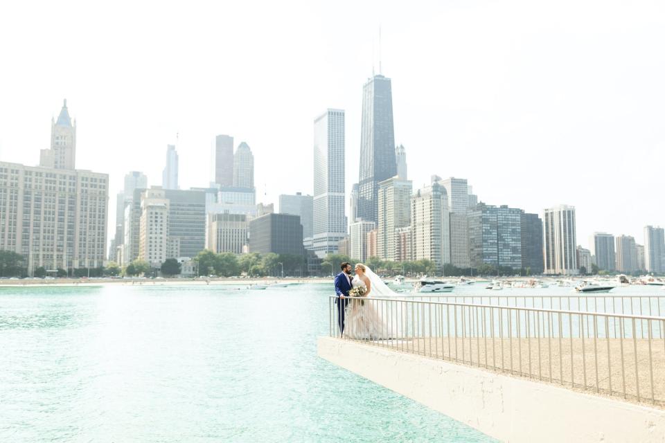 A bride and groom pose in front of Lake Michigan.