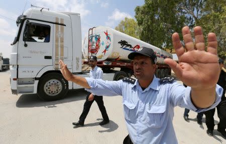 Palestinian policemen loyal to Hamas stand guard as fuel tankers enter Gaza through the Rafah border between Egypt and southern Gaza Strip June 21, 2017. REUTERS/Ibraheem Abu Mustafa