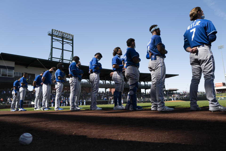 Kansas City Royals players listen to the national anthem before the team's spring baseball game against the Chicago Cubs in Mesa, Ariz., Tuesday, March 2, 2021. (AP Photo/Jae C. Hong)