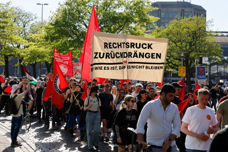People hold a banner with the slogan "Push back the shift to the right - things can't stay the way they are" during the "Revolutionary demonstration for May 1st" demonstration organized by the Roter Aufbau (Red Reconstruction).  Axel Heimken/dpa