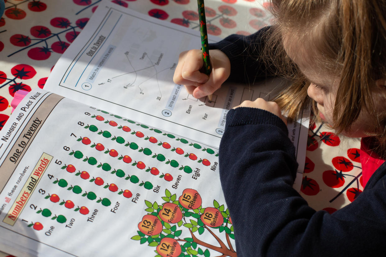 A 6-year-old girl in London fills out a maths book at her kitchen table as schools remain closed in response to the Coronavirus outbreak. Photo credit should read: Katie Collins/EMPICS