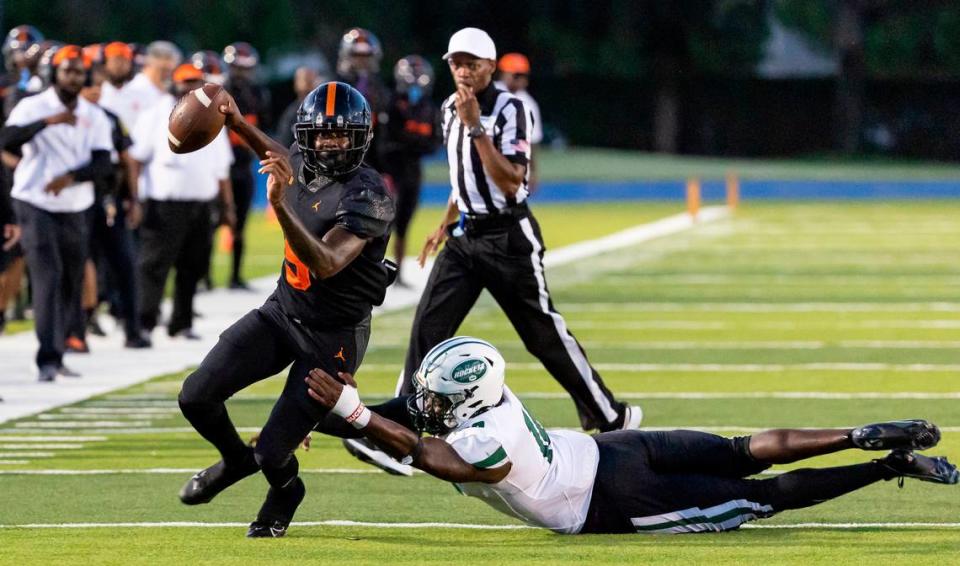 Booker T. Washington Tornadoes quarterback Claudell Sherman (5) runs with the ball as Central Rockets defensive line Armondo Blount (18) tries to tackle him during the first quarter of their high school football game at the Nathaniel Traz Powell Stadium on Friday, Sept. 8, 2023, in Miami, Fla.