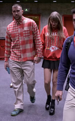 <p>AP Photo/Charlie Riedel</p> Travis Kelce and Taylor Swift hold hands in Kansas City on Oct. 22, 2023