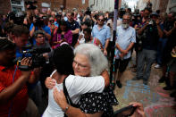 <p>Susan Bro (R), mother of Heather Heyer, hugs a young woman near a makeshift memorial for her daughter Heather who was killed one year ago during a deadly clash, August 12, 2018 in Charlottesville, Virginia. Charlottesville has been declared in a state of emergency by Virginia Gov. Ralph Northam as the city braces for the one year anniversary of the deadly clash between white supremacist forces and counter protesters over the potential removal of Confederate statues of Robert E. Lee and Jackson. A ‘Unite the Right’ rally featuring some of the same groups is planned for today in Washington, DC. (Photo: Win McNamee/Getty Images) </p>