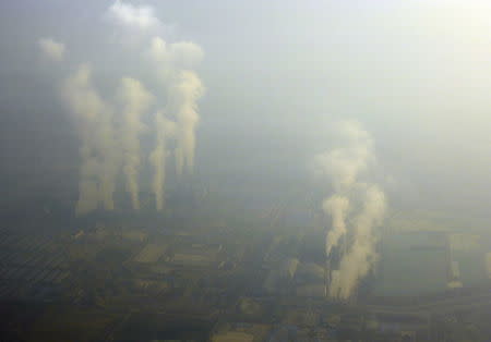 An aerial view shows smoke billowing from chimneys of factories located near Beijing, amid heavy smog under a red alert for air pollution, China, December 19, 2015. REUTERS/Stringer