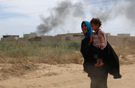 Displaced Iraqis flee during clashes between Iraqi forces and Islamic State militants in western Mosul, Iraq, May 16, 2017. REUTERS/Danish Siddiqui