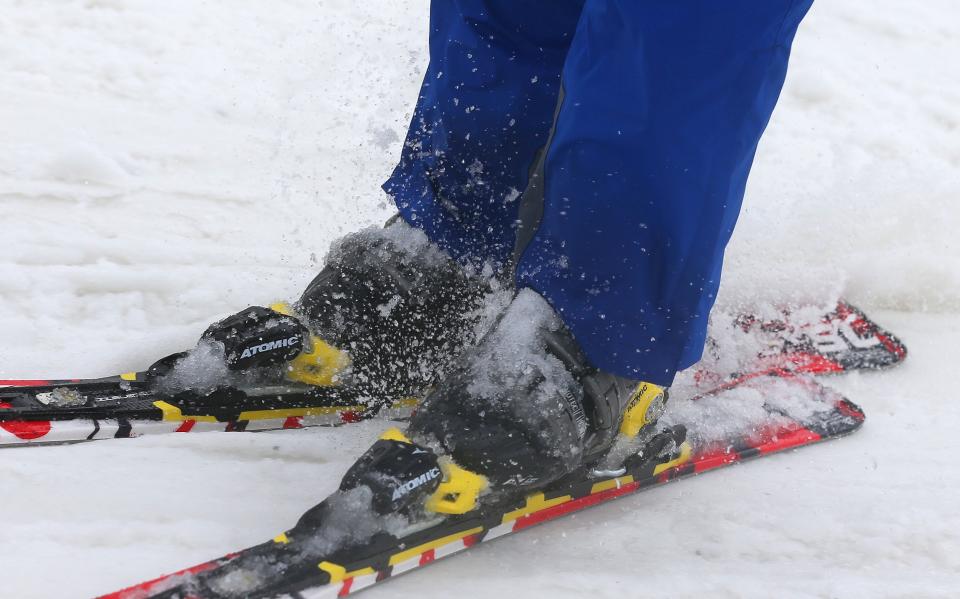 A skier makes their way through the slushy snow near the training slopes of the alpine course at the Sochi 2014 Winter Olympics, Tuesday, Feb. 11, 2014, in Krasnaya Polyana, Russia. Warm temperatures in the mountains made the snow too soft and caused the cancellation of Women's downhill training on Tuesday. (AP Photo/Luca Bruno)