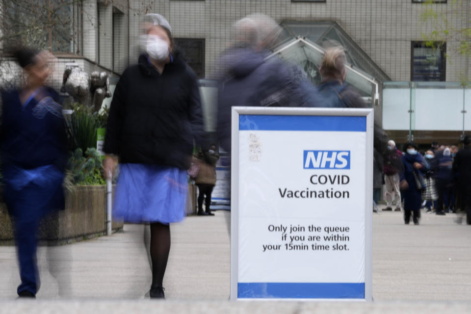 A sign marks the entrance of a vaccination centre at St Thomas' Hospital in London, Wednesday, Dec. 15, 2021. As of Monday in England, people were urged to work from home if possible, with long lines forming at vaccination centers for people to get booster shots to protect themselves against the coronavirus omicron variant. (AP Photo/Frank Augstein)