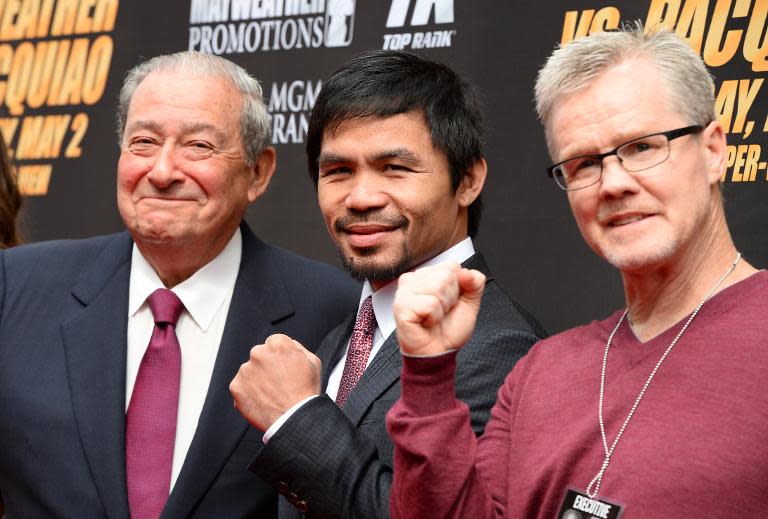 Boxer Manny Pacquiao (centre), trainer Freddie Roach (right) and promoter Bob Arum arrive for a joint press conference with Floyd Mayweather Jr on March 11, 2015 in Los Angeles, California