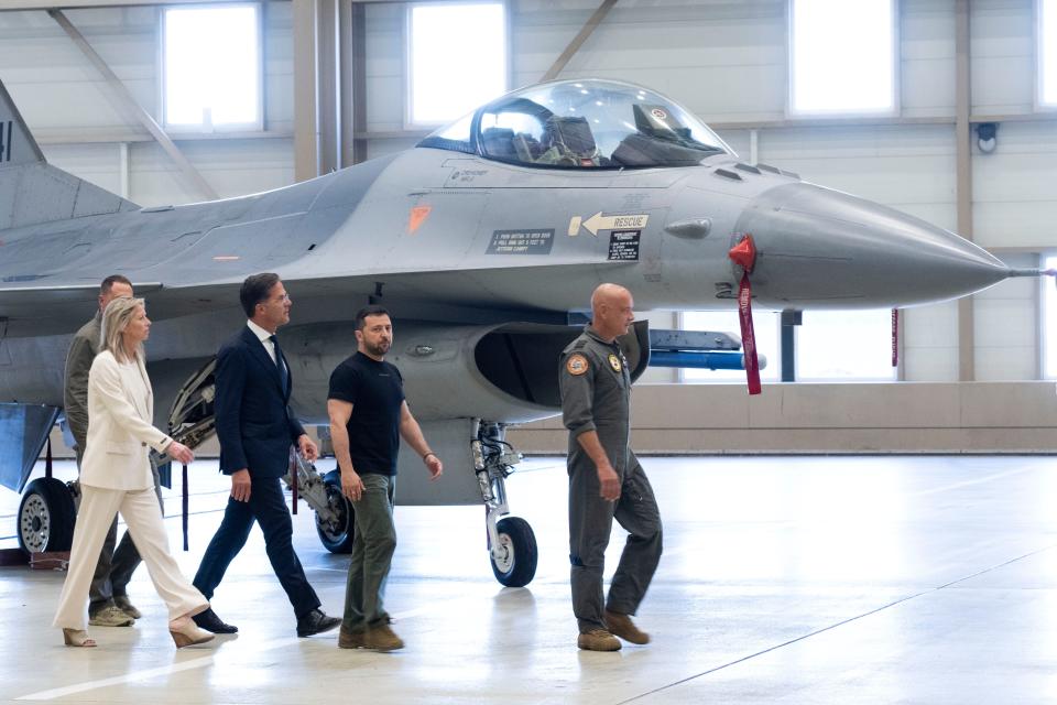 Ukrainian President Volodymyr Zelenskyy, second right, and Dutch caretaker Prime Minister Mark Rutte, center, look at F-16 fighter jets in Eindhoven, Netherlands, on Aug. 20, 2023.