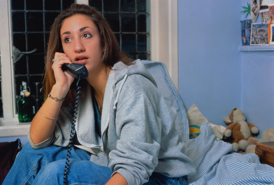 A young girl on a corded landline phone