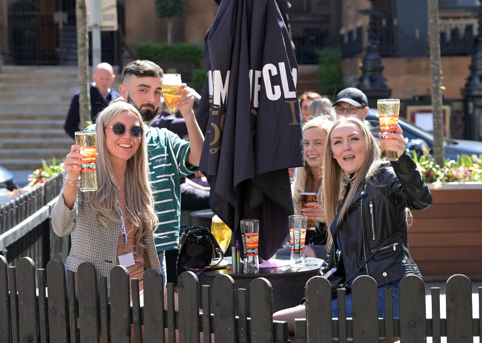 People raise their glasses as pubs with outdoor facilities reopen on 30 April in Belfast, Northern Ireland. Photo: Charles McQuillan/Getty Images