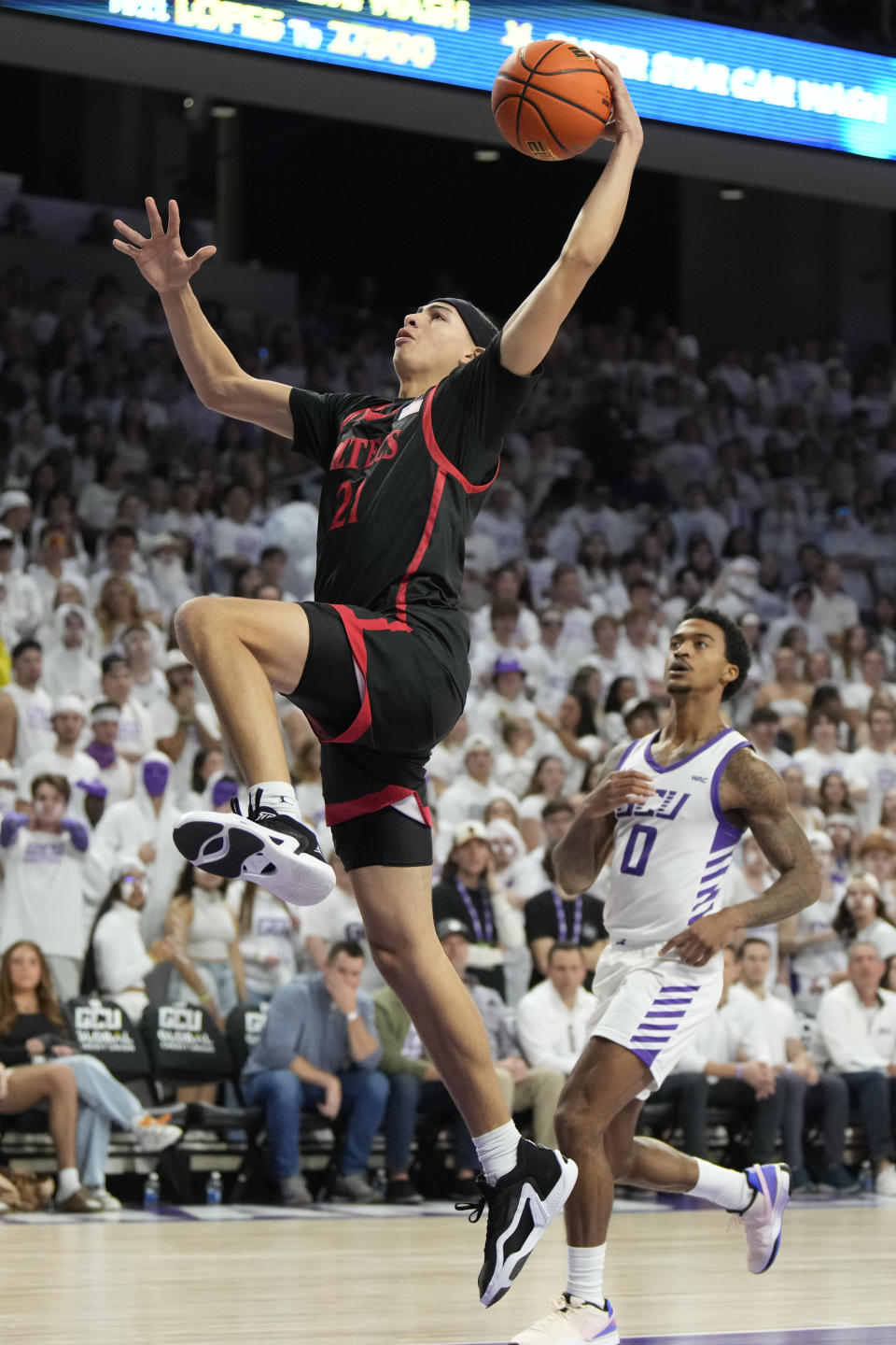 San Diego State guard Miles Byrd shoots next to Grand Canyon guard Ray Harrison (0) during the first half of an NCAA college basketball game Tuesday, Dec. 5, 2023, in Phoenix. (AP Photo/Rick Scuteri)