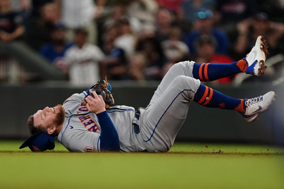 New York Mets second baseman Travis Blankenhorn falls after catching a fly ball from Atlanta Braves' Ronald Acuna Jr. duirng the sixth inning of a baseball game Wednesday, June 30, 2021, in Atlanta. (AP Photo/John Bazemore)