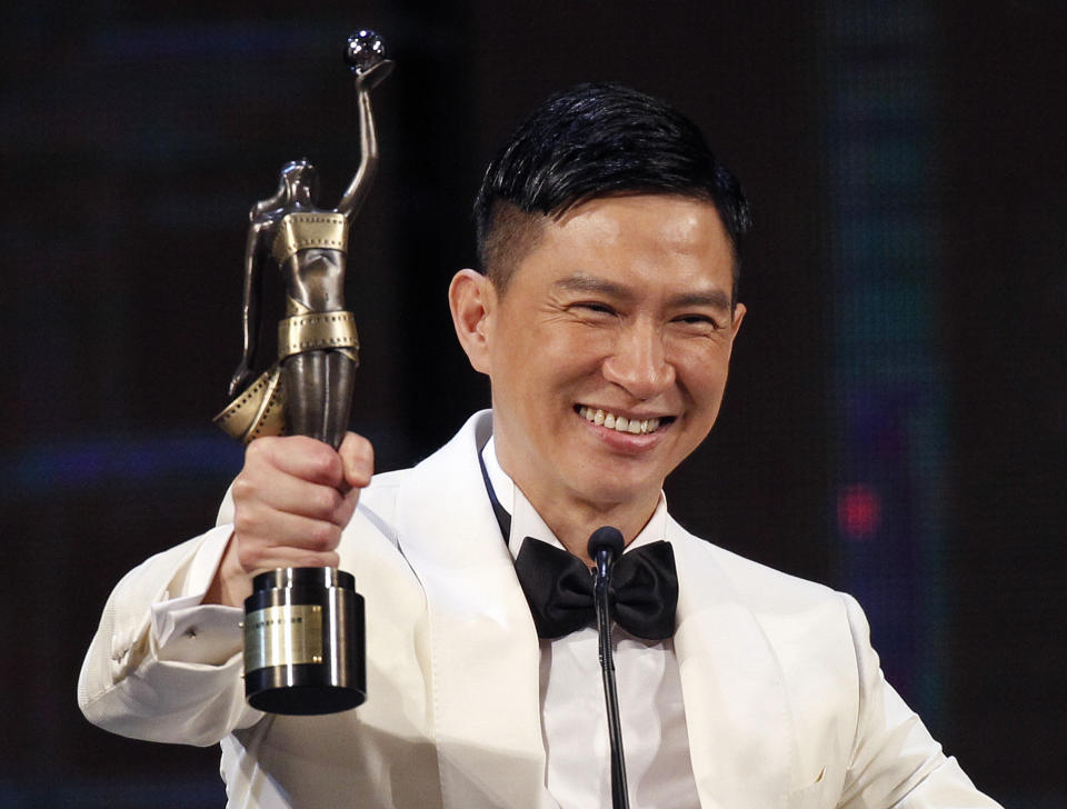 Hong Kong actor Cheung Ka Fai raises the trophy after winning the Best Actor award for his role in the movie ' The Unbeatable' at the 33rd Hong Kong Film Awards in Hong Kong, Sunday, April 13, 2014. (AP Photo/Vincent Yu)