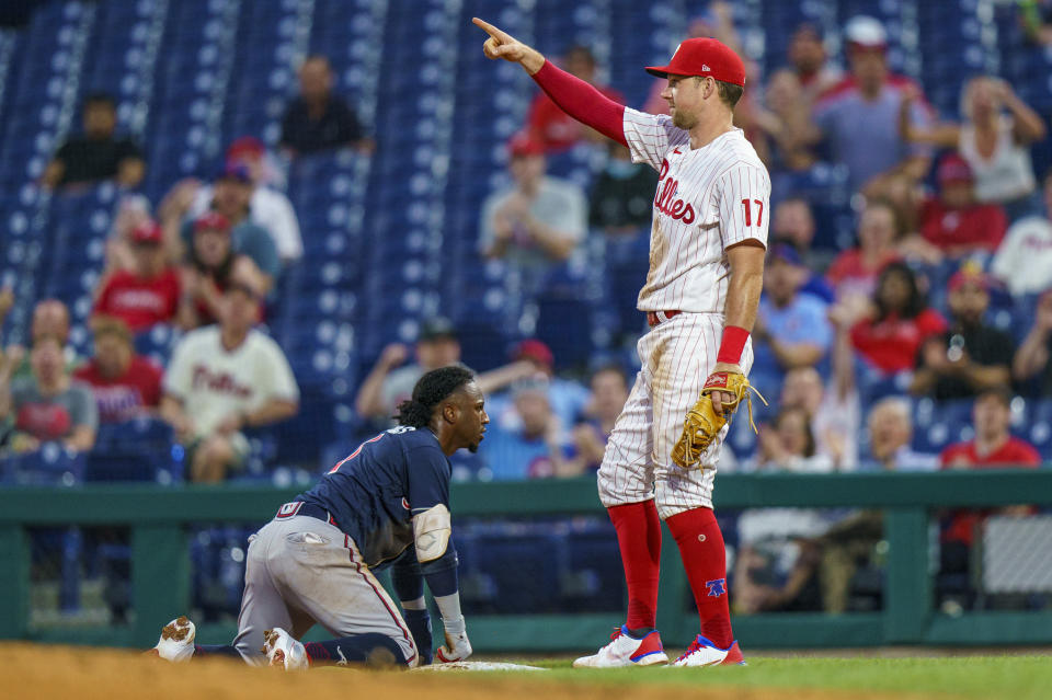 Philadelphia Phillies first baseman Rhys Hoskins, right, reacts to the throw by Jean Segura to double off Atlanta Braves' Ozzie Albies, left, at first after a lineout by Austin Riley during the third inning of a baseball game Wednesday, June 9, 2021, in Philadelphia. (AP Photo/Chris Szagola)