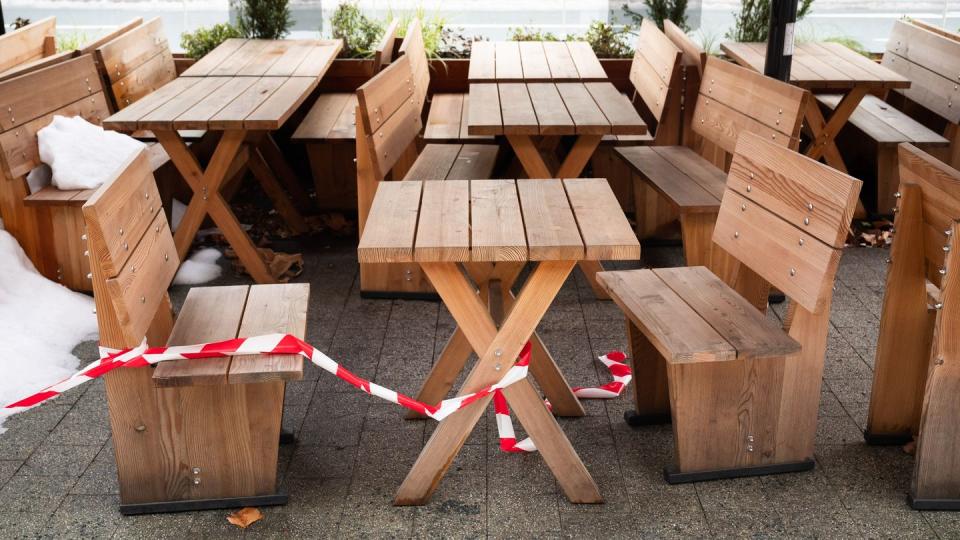 Absperrband liegt über Tischen und Stühlen vor einem Restaurant in der Innenstadt von Hannover.