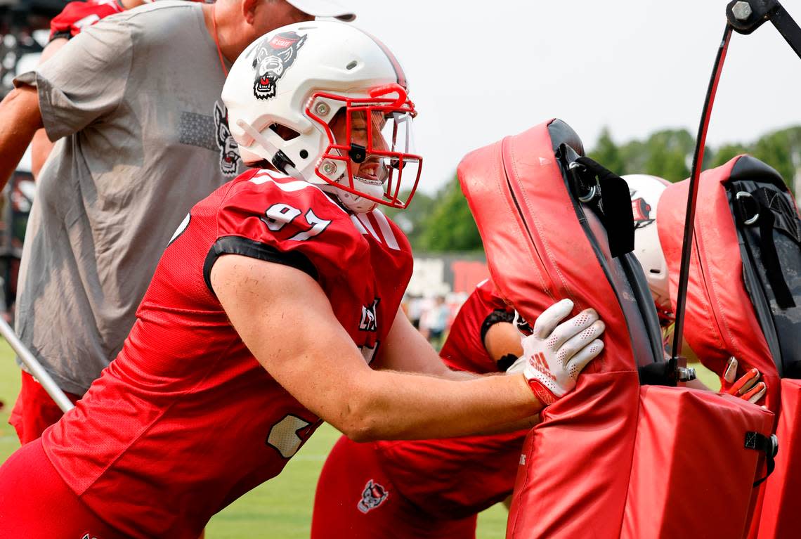 N.C. State defensive lineman Noah Potter (97) hits the pad during the Wolfpack’s first fall practice in Raleigh, N.C., Wednesday, August 2, 2023. Ethan Hyman/ehyman@newsobserver.com