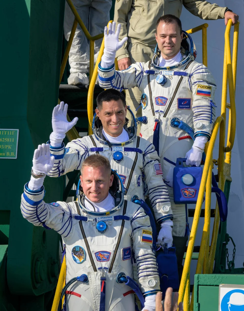 Expedition 68 crew members Dmitri Petelin of Roscosmos, top, Frank Rubio of NASA, and Sergey Prokopyev of Roscosmos, bottom, wave farewell prior to boarding the Soyuz MS-22 spacecraft for launch, Wednesday, Sept. 21, 2022, at the Baikonur Cosmodrome in Kazakhstan.