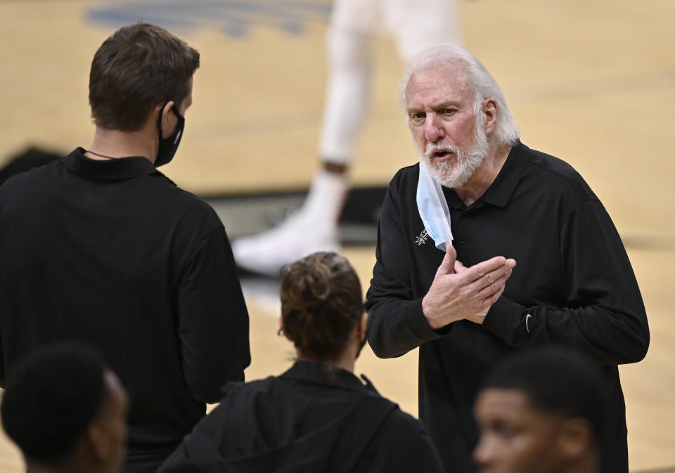 San Antonio Spurs coach Gregg Popovich, right, talks to assistant coaches Becky Hammon, center, and Will Hardy during the second half of the team's NBA basketball game against the Toronto Raptors, Saturday, Dec. 26, 2020, in San Antonio. San Antonio won 119-114. (AP Photo/Darren Abate)