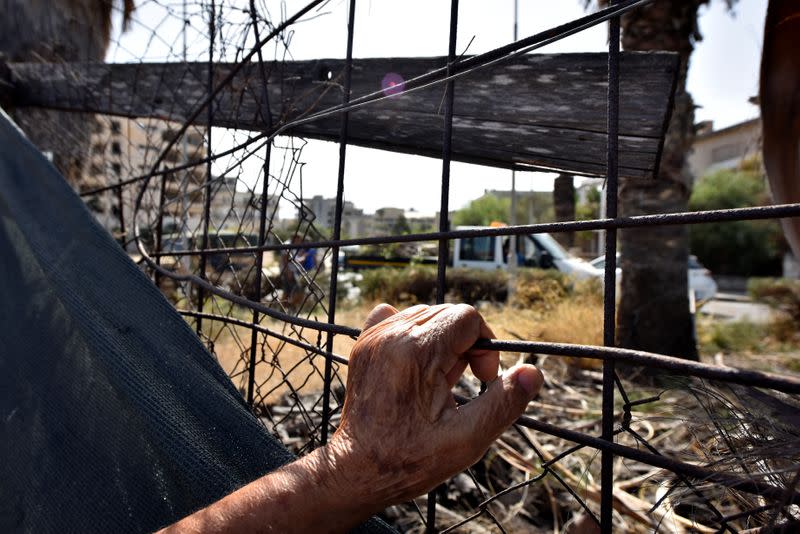 A man holds a fence in the abandoned coastal area of Varosha