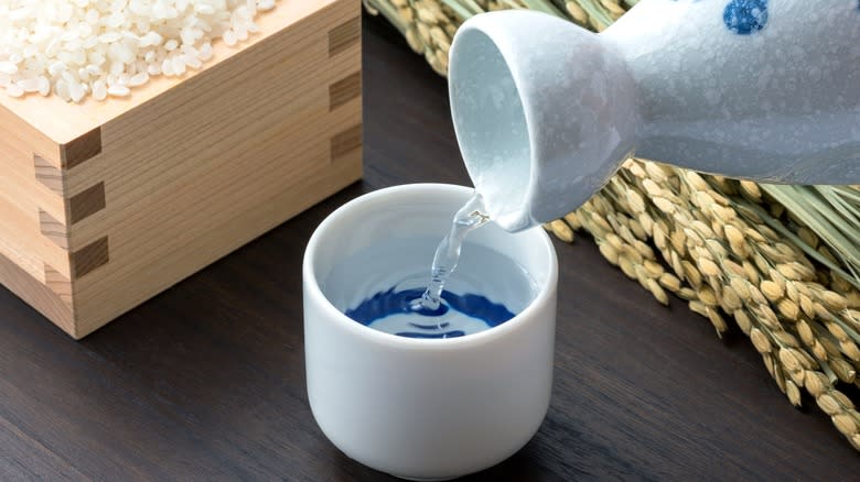 Rice sake being poured into porcelain cup 